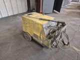 un chariot jaune sur lequel est posée une machine, dans un garage