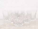 quatre verres posés sur une table, avec un mur de briques en arrière-plan