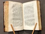 an open book with two wooden sticks sticking out of it