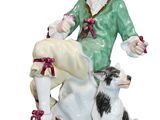 a figurine of a woman with a dog on a rock