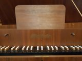 a close up of a piano keyboard with a wooden case