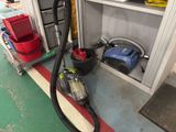 a vacuum that is sitting on the floor next to a shelf