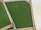 two green chairs sitting next to each other on a white surface