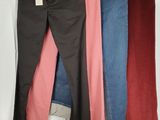 three pairs of jeans hanging on a rack in front of a white curtain