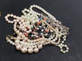 a pile of pearls and other jewelry on a table