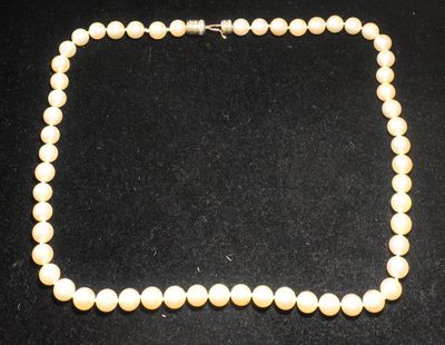 gros plan d'un collier de perles sur une surface noire