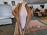 a mannequin with a fur coat on it in a room