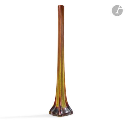 une image représentant un grand vase en verre posé sur une surface blanche