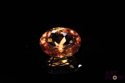 gros plan d'un diamant orange sur une surface noire