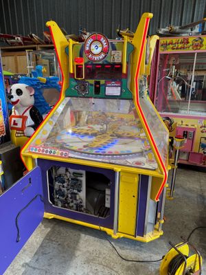 une image représentant un flipper dans une pièce où se trouvent d'autres jeux