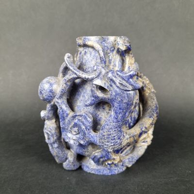 a blue vase with a dragon on it sitting on a table