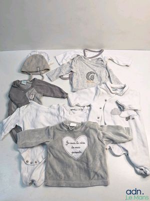 beaucoup de vêtements de bébé étalés par terre