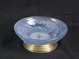 a blue glass bowl with a gold rim on a black background