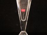 a clear glass vase with a red label on it