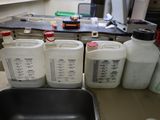 many bottles of liquid sitting on a counter in the kitchen