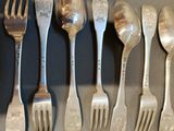 a lot of forks and spoons that are on a table