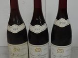 three bottles of wine are lined up on a table