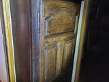 a tall wooden cabinet in the corner of a room