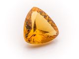 a close up of a yellow diamond on a white surface