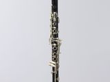 a black and white clarinet sitting on top of a clear stand