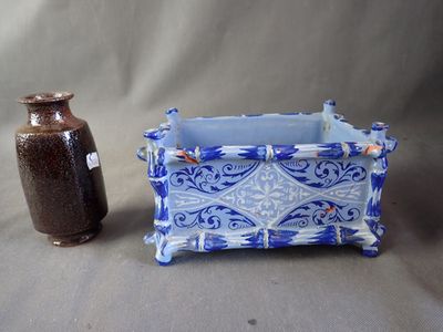 a blue and white vase next to a brown vase