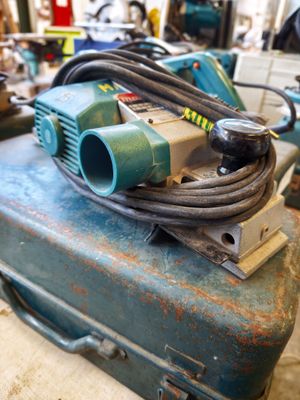 a blue suitcase with a hose on top of it