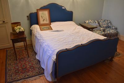 a bed with a blue headboard and a picture frame on it