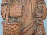 a wooden statue of a man holding a basket