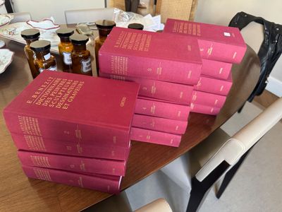 de nombreux livres posés sur une table, avec une chaise en arrière-plan