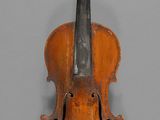 an old violin sitting on top of a table next to a wall