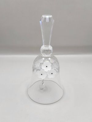 une cloche en verre transparent posée sur une table avec un fond blanc