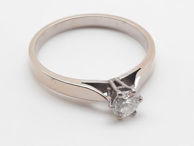 gros plan d'une bague en diamant sur une surface blanche