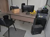 a desk with a computer monitor and a printer on it