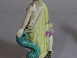 two figurines of a man and a woman sitting on a rock