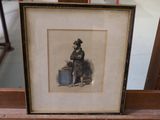 a framed picture of a man sitting on a chair
