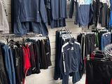 beaucoup de vêtements suspendus à une étagère dans un magasin