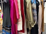 a lot of clothes hanging on a rack in a room