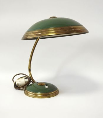 une lampe de bureau verte et dorée sur laquelle se trouve une horloge