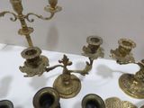 a lot of antique brass candlesticks on a table