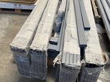 Plusieurs pièces d'acier sont empilées sur des palettes dans un entrepôt
