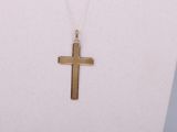 a close up of a necklace with a cross on a mannequin