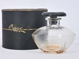 une image représentant un flacon de parfum posé à côté d'une boîte noire