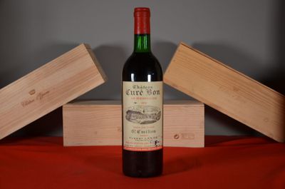 a bottle of wine sitting on a table next to two wooden boxes