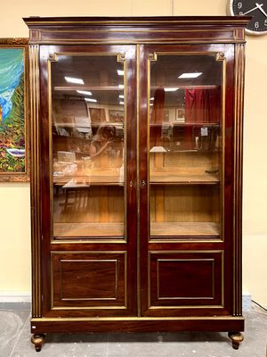 a large wooden cabinet with glass doors in a room