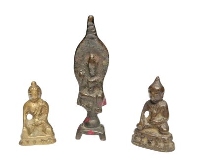 trois petites figurines de Bouddha en bronze posées sur une surface blanche