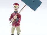 une petite figurine représentant un homme tenant une pancarte