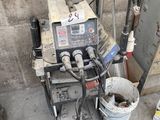 a machine that is sitting on the ground next to a bucket