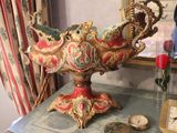 a vase on a table with a clock on it