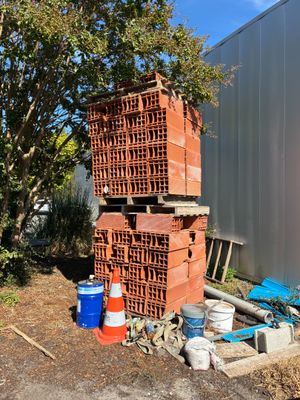 un tas de briques posé par terre à côté d'un bâtiment