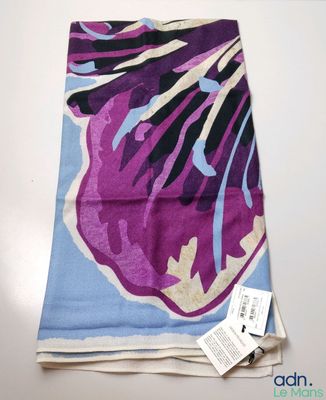 foulard à motifs floraux violets et bleus posé sur une nappe blanche